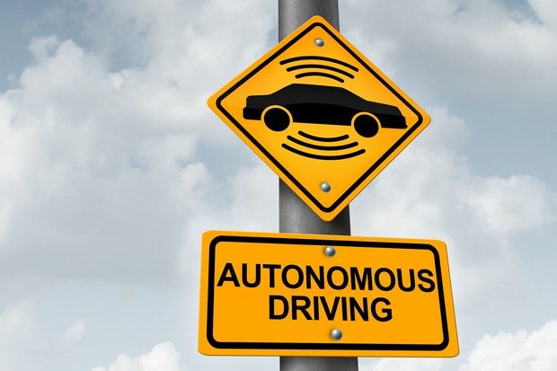 Yellow road sign showing a black image of a car with WIFI image above and below along with sign below saying 'autonomous vehicle'