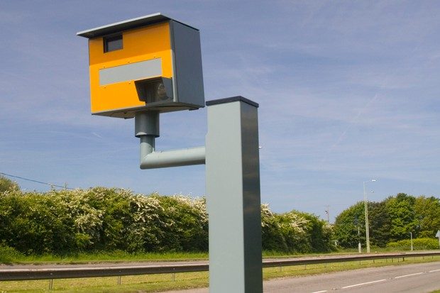 Yellow and grey GATSO speed camera on a road.