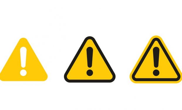 Three yellow caution triangular road signs two with black exclamation marks inside one with a white exclamation mark.